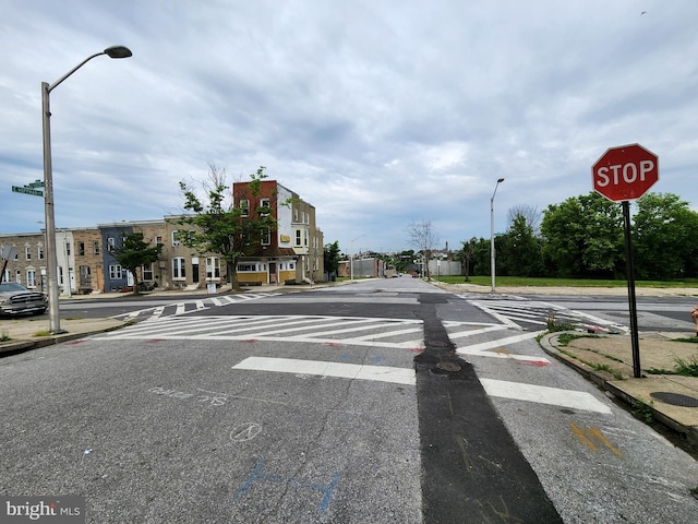 view of road featuring traffic signs, curbs, and sidewalks