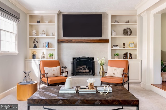 sitting room with baseboards, carpet flooring, a fireplace with raised hearth, and built in shelves
