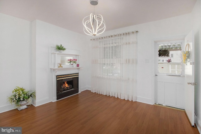 4558 Unruh Ave, Philadelphia, PA 19135 - unfurnished living room featuring wood finished floors, a chandelier, a lit fireplace, and baseboards