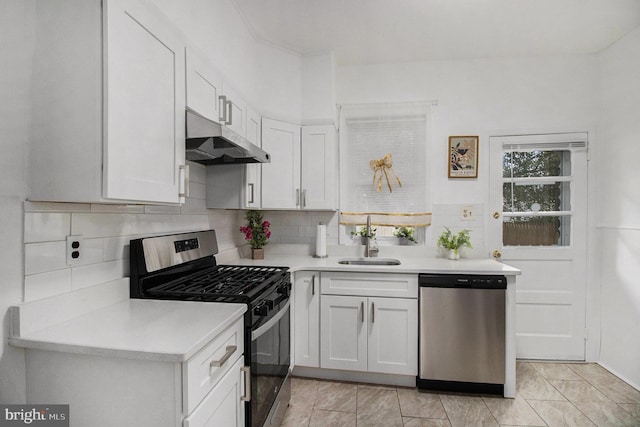 4558 Unruh Ave, Philadelphia, PA 19135 - kitchen with stainless steel appliances, under cabinet range hood, light countertops, a sink, and white cabinets
