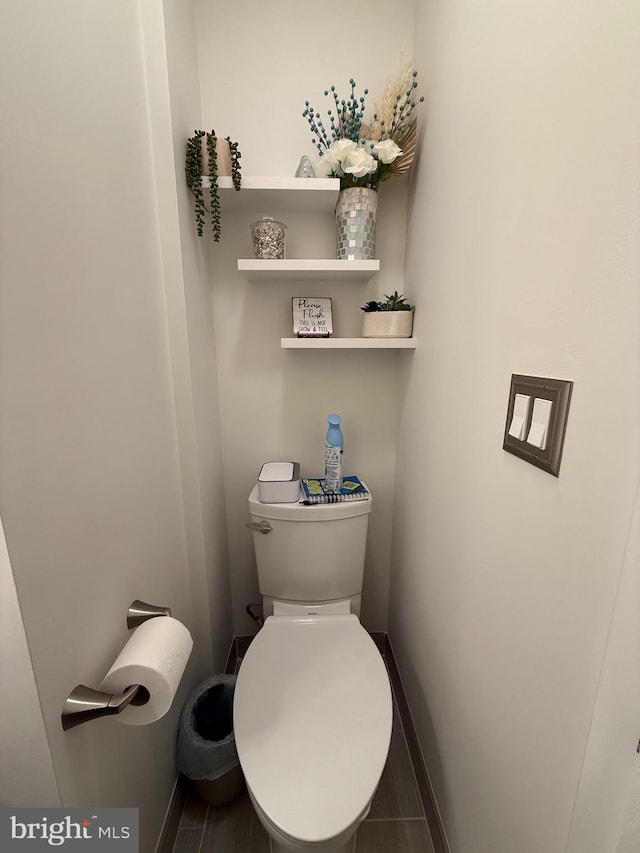 bathroom featuring toilet and baseboards