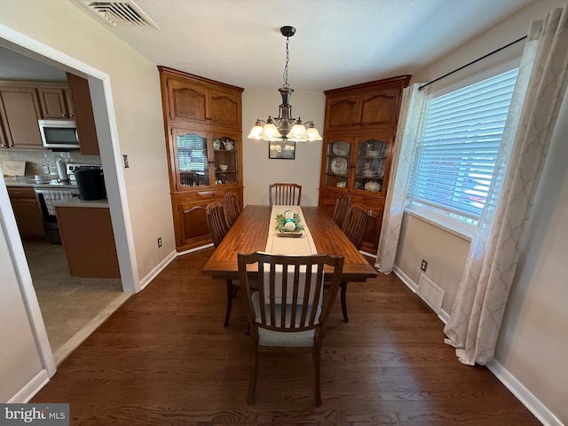 dining room with an inviting chandelier, dark wood-type flooring, and visible vents