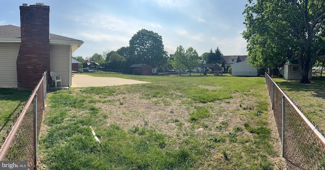view of yard with an outbuilding, fence, and a storage unit
