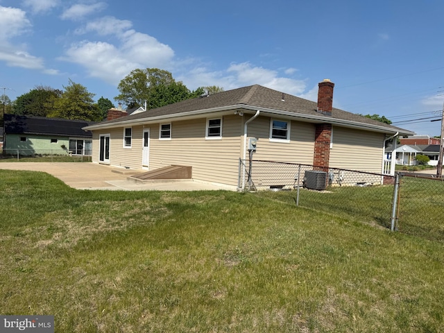 back of house with a patio, cooling unit, a chimney, fence, and a yard