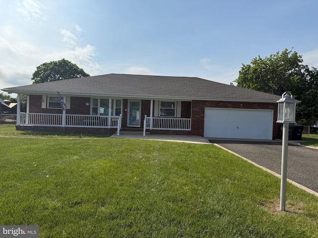 ranch-style house with covered porch, aphalt driveway, roof with shingles, a garage, and a front yard