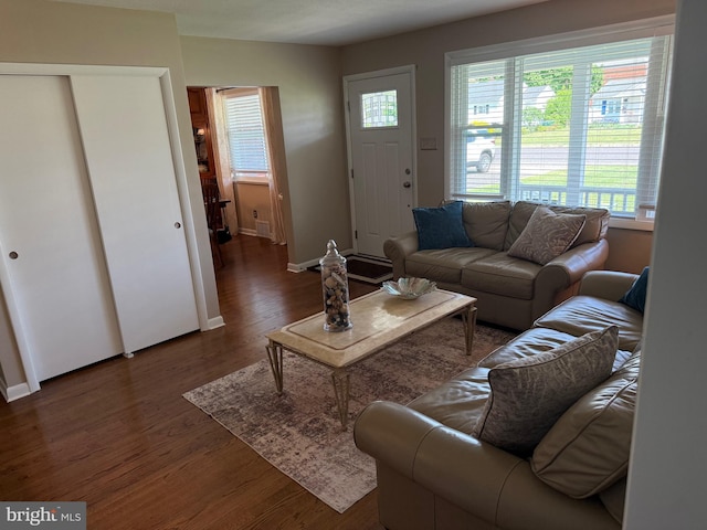 living area featuring baseboards, dark wood finished floors, and plenty of natural light