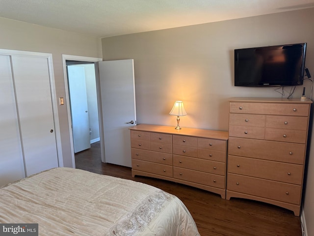 bedroom with a closet and dark wood-style flooring