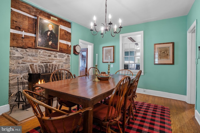 509 Ben Venue Rd, Flint Hill, VA 22627 - dining space featuring baseboards, a chandelier, wood finished floors, and a stone fireplace