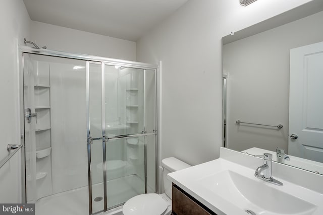 bathroom with toilet, vanity, and a shower stall