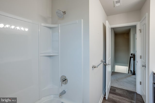 bathroom with bathtub / shower combination, visible vents, and wood finished floors