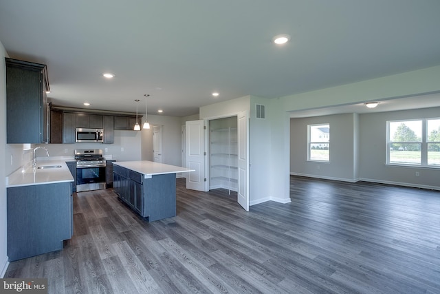 kitchen featuring open floor plan, visible vents, dark wood-type flooring, light countertops, and appliances with stainless steel finishes
