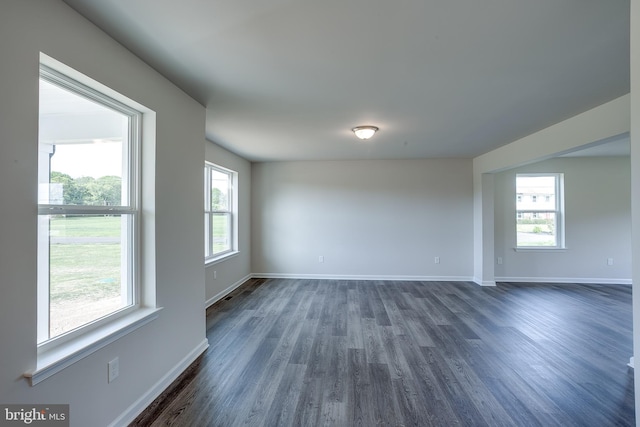 unfurnished room featuring dark wood-style flooring and baseboards
