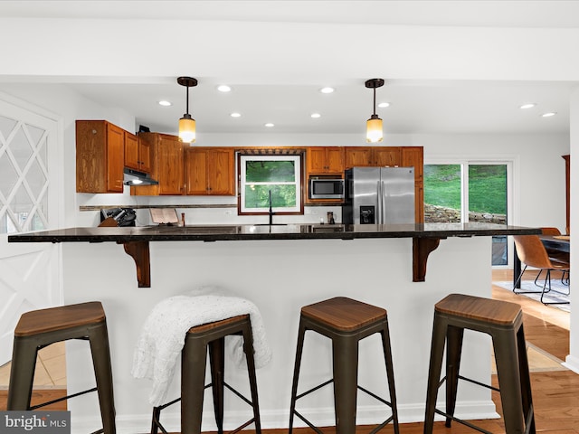 5306 Stone Rd, Frederick, MD 21703 - kitchen featuring stainless steel appliances, under cabinet range hood, recessed lighting, decorative light fixtures, and brown cabinets