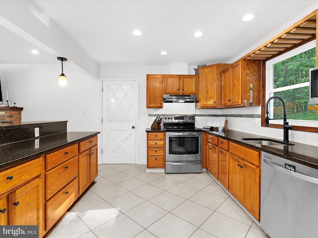 5306 Stone Rd, Frederick, MD 21703 - kitchen featuring stainless steel appliances, under cabinet range hood, brown cabinets, decorative backsplash, and dark stone countertops