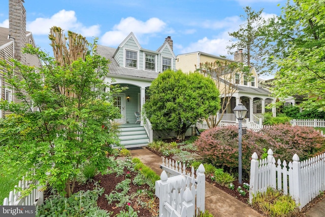 new england style home featuring stairs, covered porch, and fence