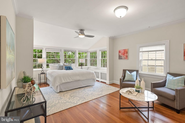 bedroom with multiple windows, ornamental molding, radiator heating unit, and wood finished floors