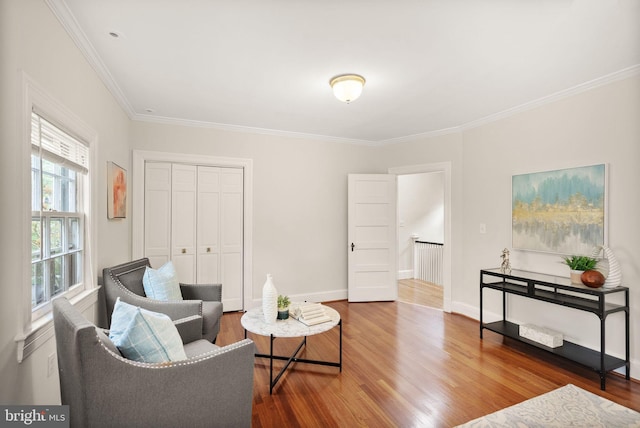 sitting room with crown molding, wood finished floors, and baseboards
