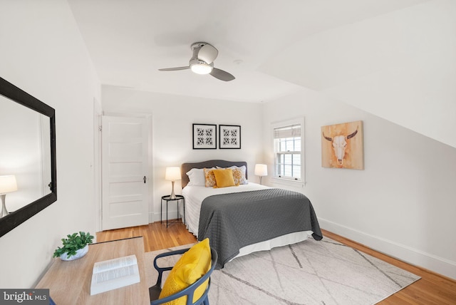 bedroom with ceiling fan, baseboards, and wood finished floors