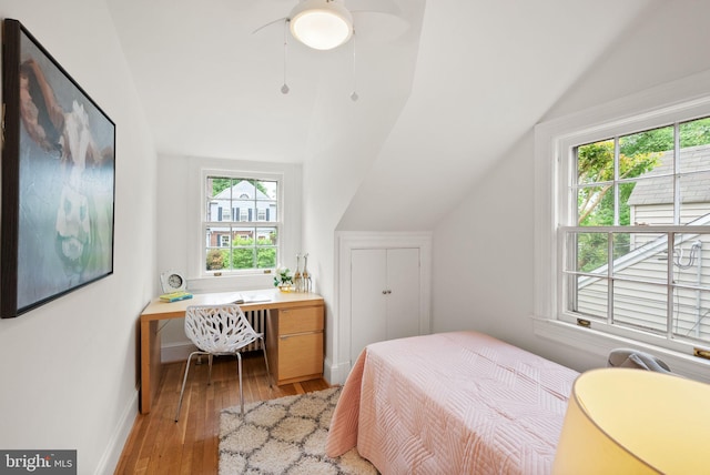 bedroom with ceiling fan, lofted ceiling, baseboards, and light wood-style floors