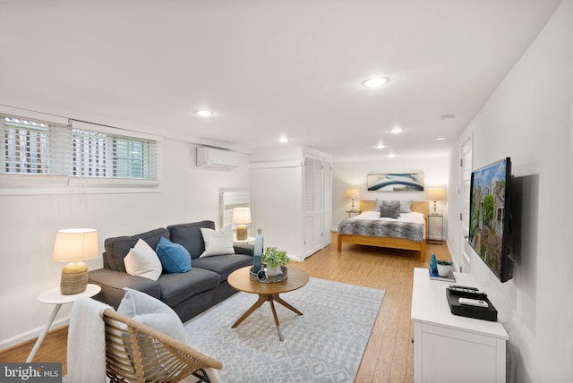 interior space featuring baseboards, light wood-style floors, recessed lighting, and a wall mounted AC