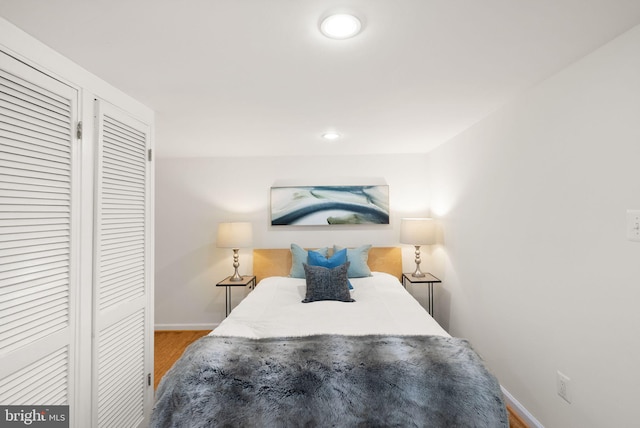 bedroom with wood finished floors, baseboards, and recessed lighting