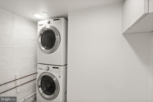 clothes washing area featuring laundry area and stacked washer and dryer