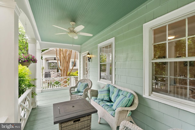 sunroom / solarium featuring a ceiling fan