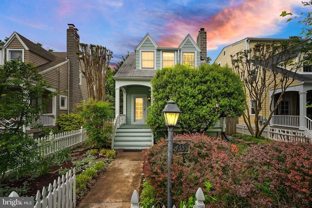 view of front of property featuring a porch and fence