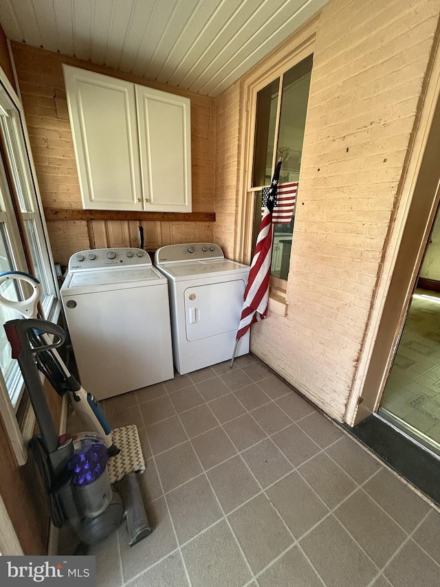 clothes washing area with dark tile patterned floors, cabinet space, washer and clothes dryer, wood walls, and wooden ceiling