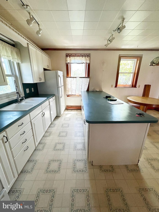 kitchen featuring track lighting, dark countertops, and ornamental molding