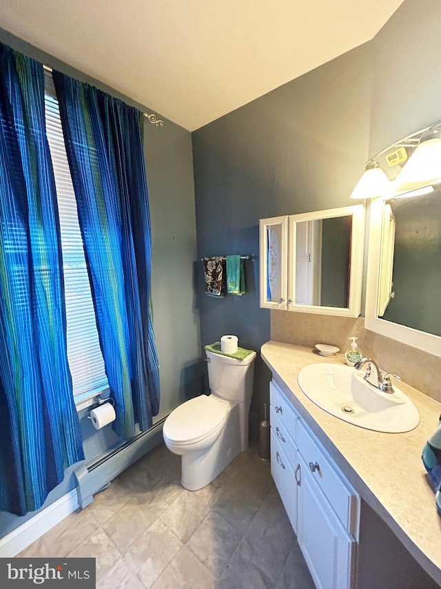 bathroom with toilet, lofted ceiling, vanity, and a baseboard radiator