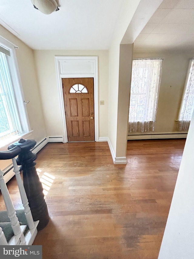 foyer featuring baseboards, wood finished floors, a baseboard radiator, and a baseboard heating unit
