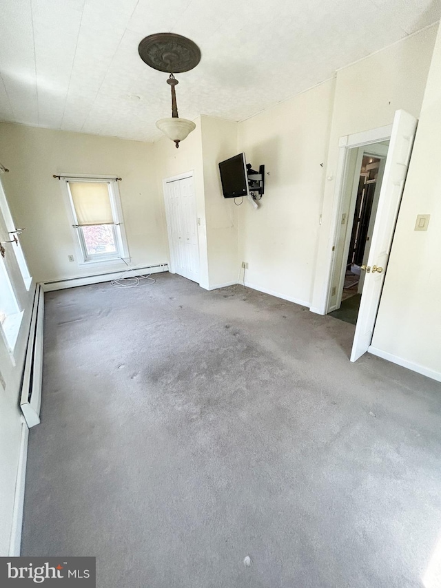 carpeted empty room featuring baseboards and baseboard heating
