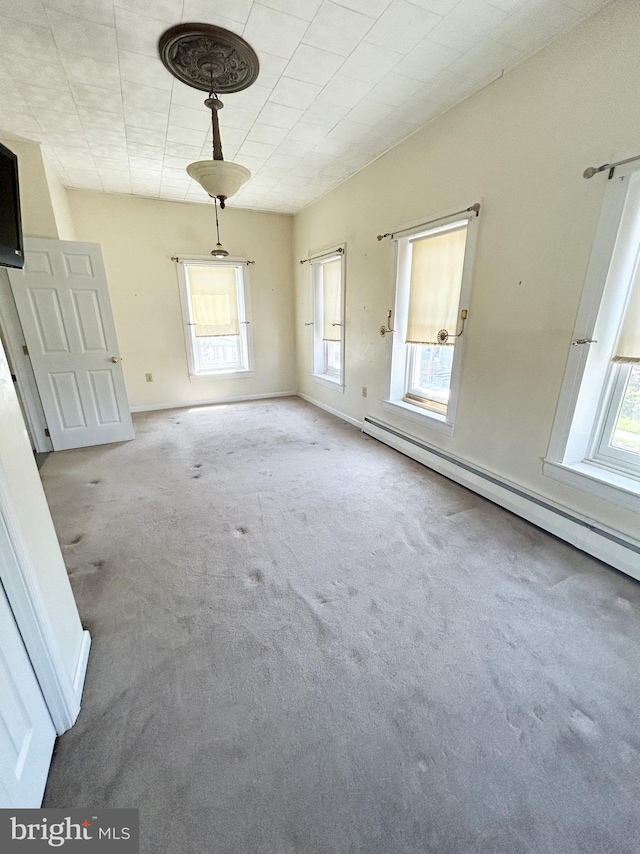 interior space featuring a wealth of natural light, carpet, and baseboard heating