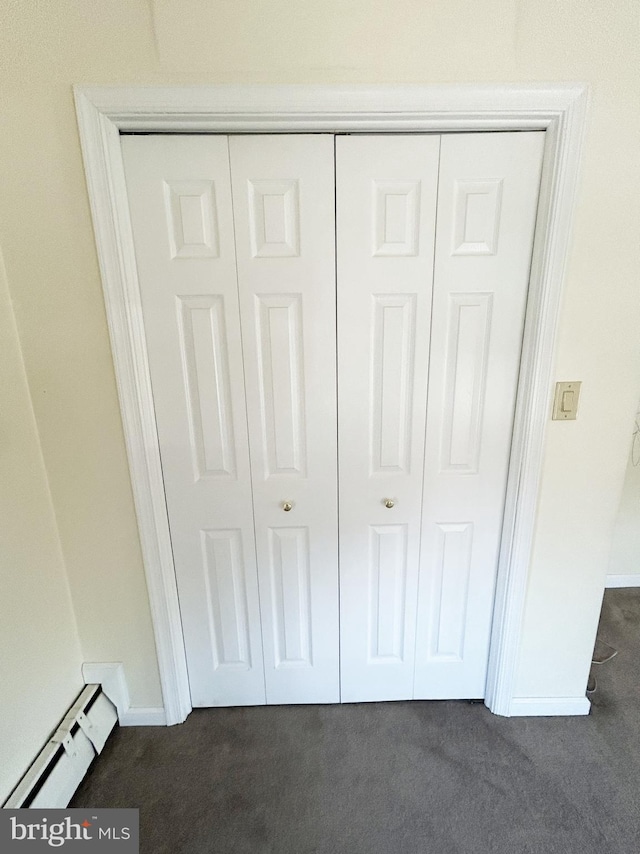 room details featuring carpet flooring, baseboards, and a baseboard heating unit