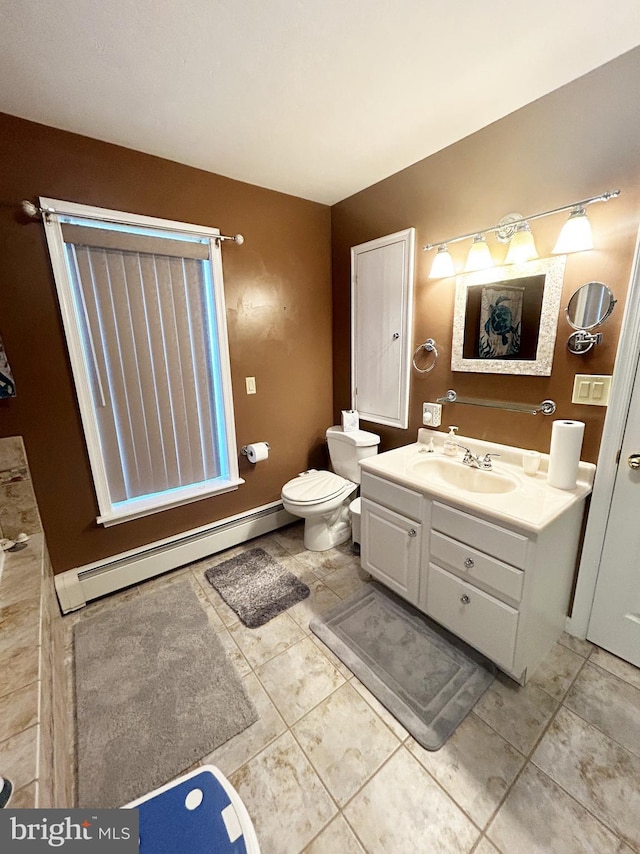bathroom with a baseboard heating unit, tile patterned floors, vanity, and toilet