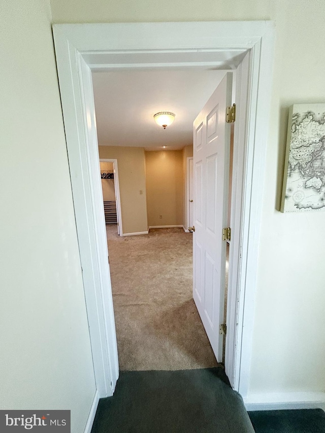 corridor with baseboards and carpet floors