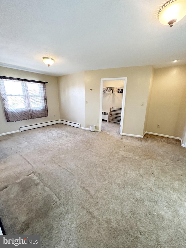 empty room with carpet, baseboards, and baseboard heating