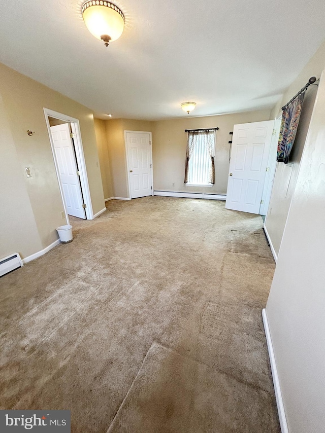 spare room with carpet flooring, baseboards, and baseboard heating