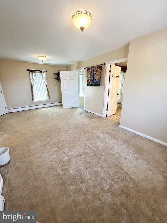 unfurnished living room with a baseboard radiator, carpet, and baseboards