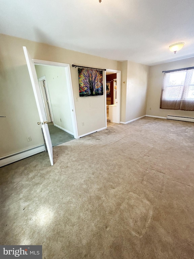 unfurnished living room featuring a baseboard heating unit, baseboards, baseboard heating, and carpet floors