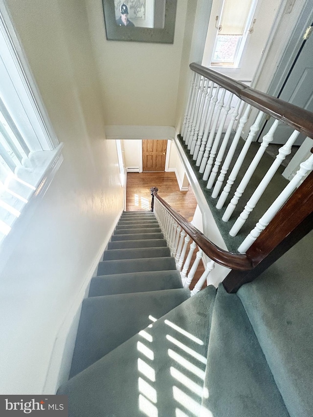 stairs featuring wood finished floors and baseboards