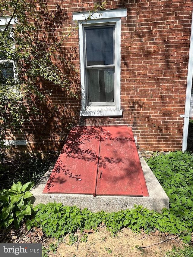 details featuring a bulkhead entry and brick siding