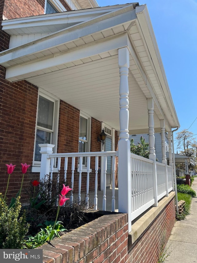 view of property exterior with a porch and brick siding