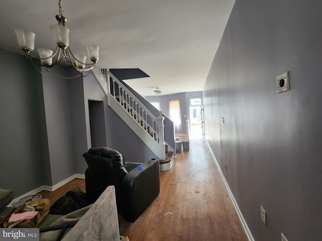 1904 Kennedy Ave, Baltimore, MD 21218 - hallway featuring baseboards, a notable chandelier, stairway, and hardwood / wood-style floors