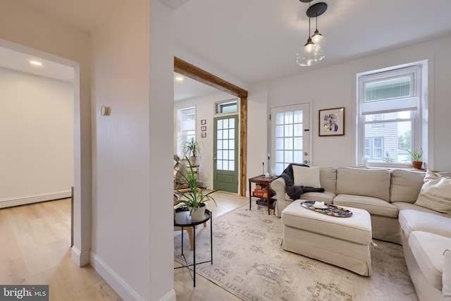 living room featuring baseboards, light wood-style flooring, and recessed lighting