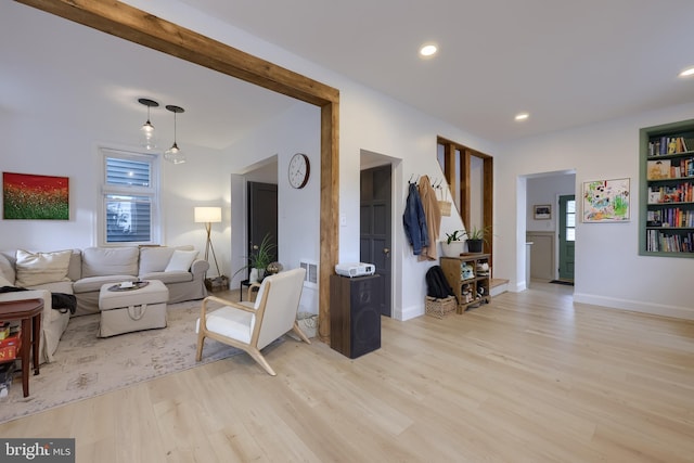 living room with light wood-style floors, visible vents, baseboards, and recessed lighting