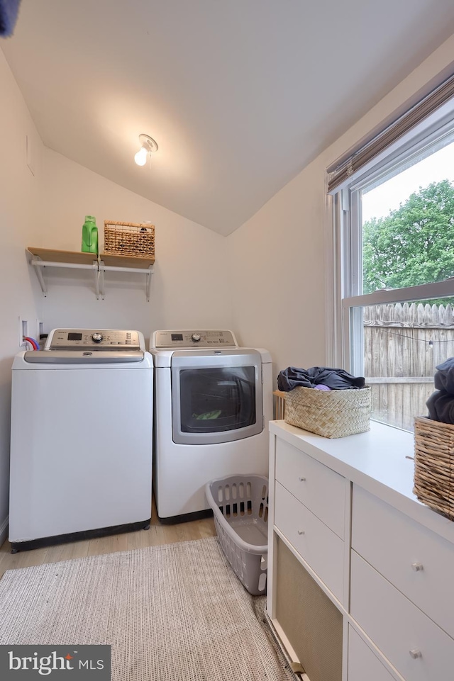clothes washing area featuring laundry area, independent washer and dryer, and light wood-style flooring