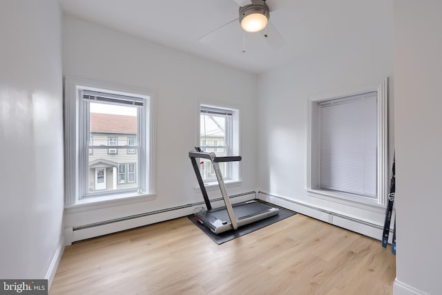 workout area featuring ceiling fan, baseboards, and wood finished floors