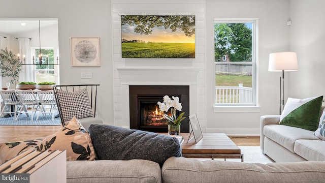 409 Crownleaf Dr, Middletown, DE 19709 - living area with an inviting chandelier, a lit fireplace, wood finished floors, and baseboards